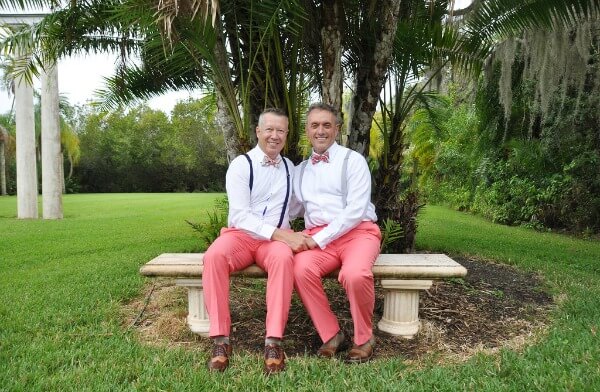 A gay couple sitting on a bench, smiling